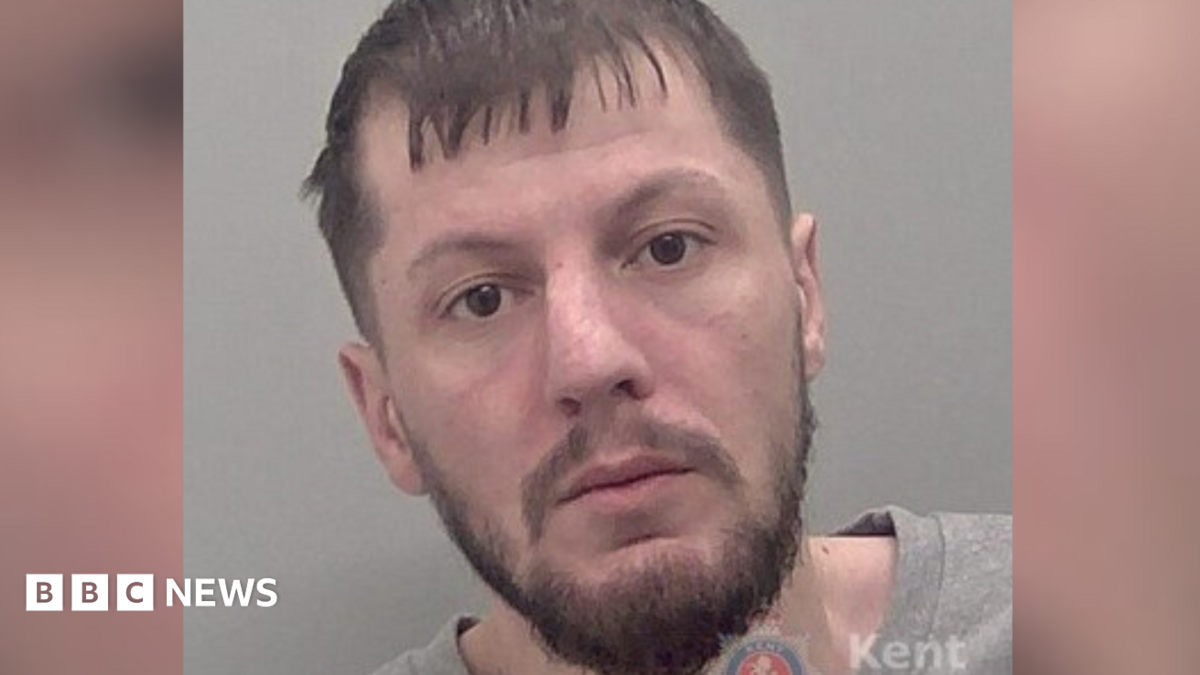 A police custody image of a man with a beard