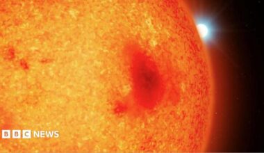An illustration of what appears to be a large red fiery planet with a white star peeking out from behind it, in a black sky.