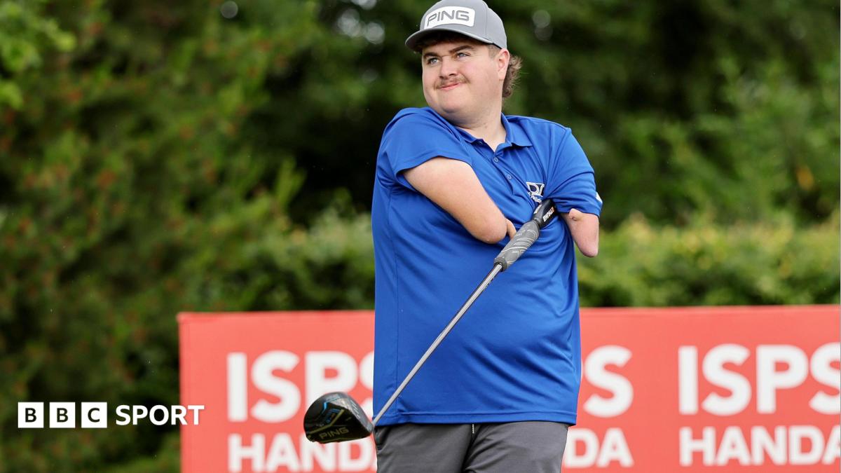 Adam Dalton wearing a blue shirt tucks a golf club under his armpit