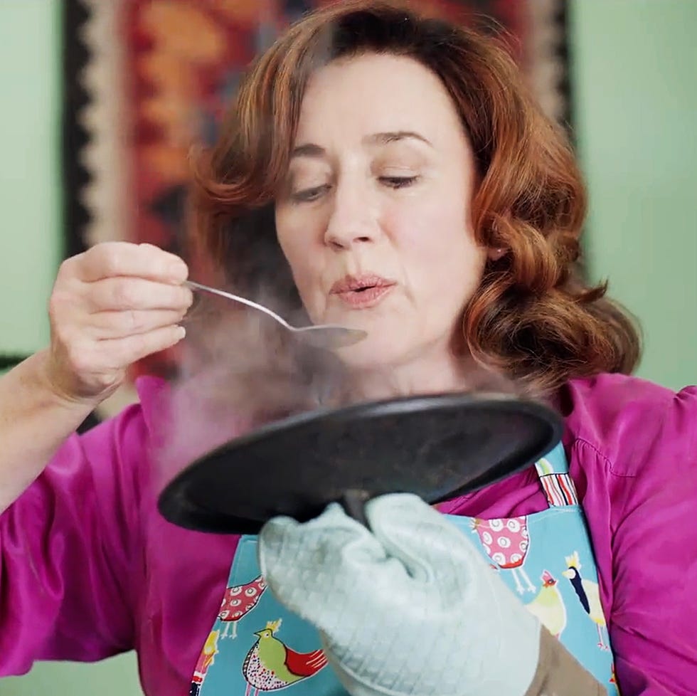 woman tasting food from a steaming pan. woman tasting food from a steaming pan.