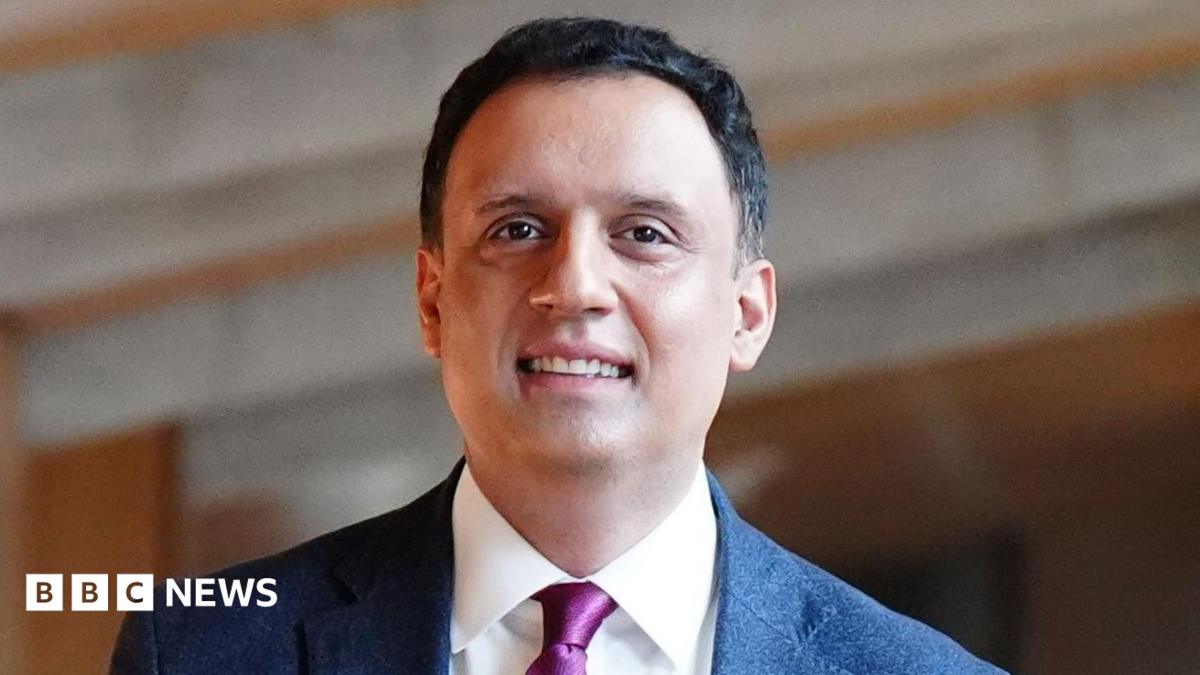 Anas Sarwar wears a dark suit and has short dark hair