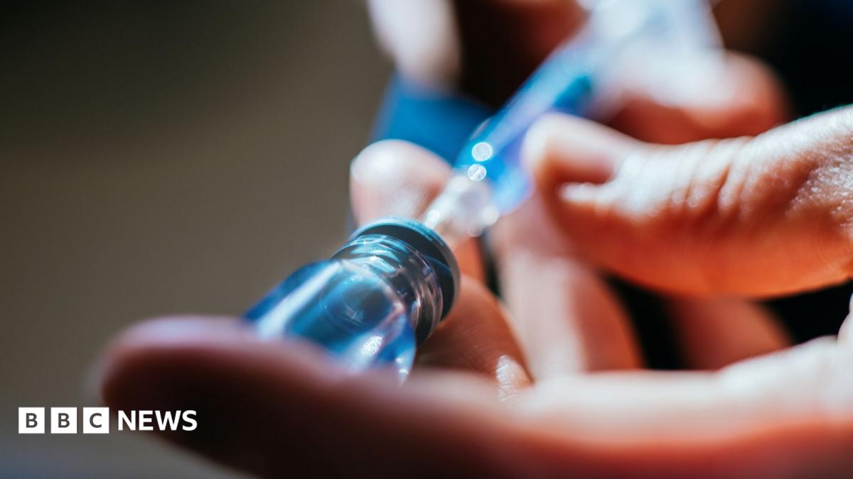 A close up of a person's hands as they prepare an injection