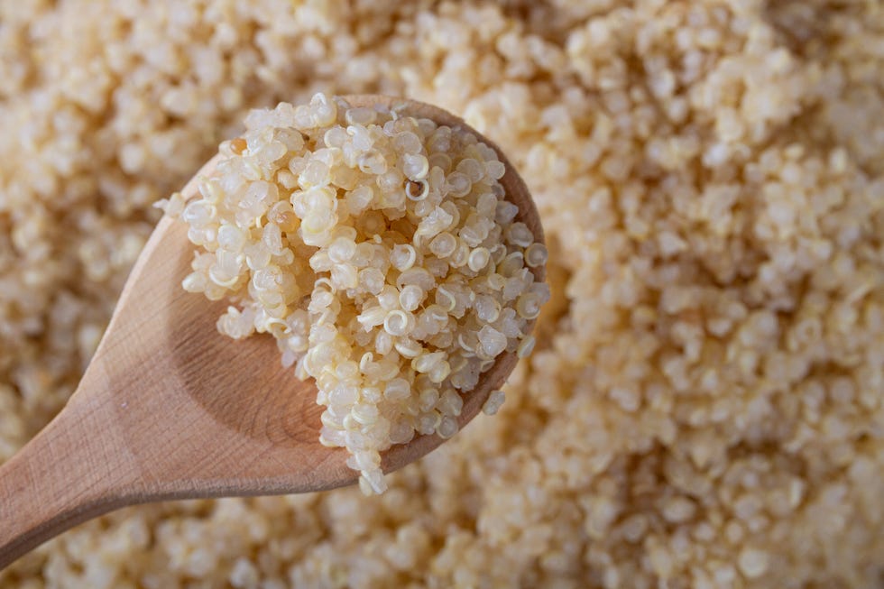 cooked quinoa on wooden spoon top view