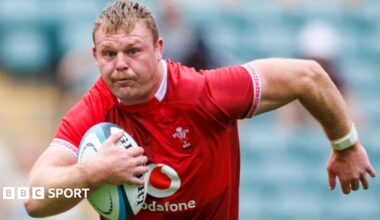 Dewi Lake in red Wales jersey runs with ball under his right arm
