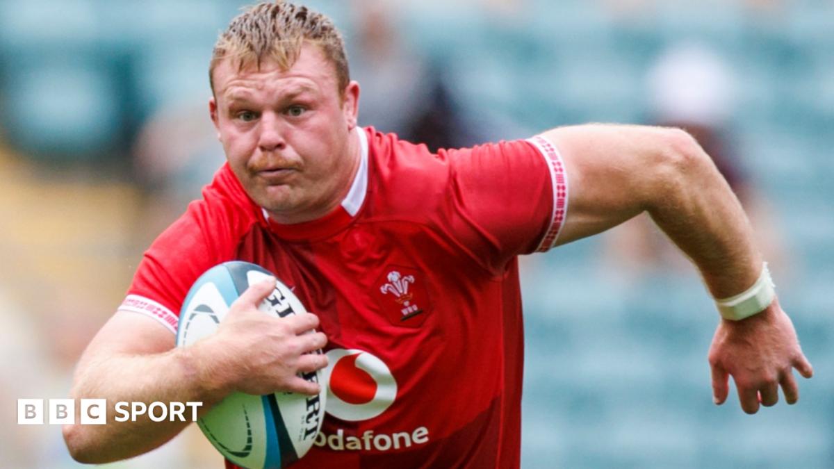 Dewi Lake in red Wales jersey runs with ball under his right arm