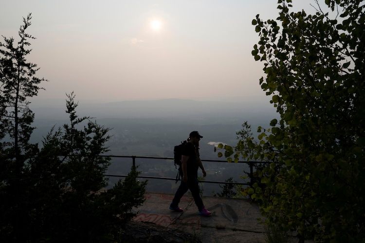 A man is seen hiking as haze from wildfires is visible in Holyoke, Mass. (Photo: AP)