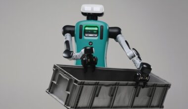 A humanoid robot with a green torso holds a large bin in two hands.