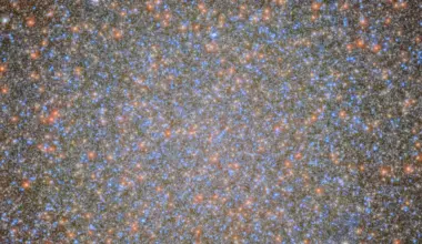An image of the globular cluster Omega Centauri, a collection of myriad stars colored red, white, and blue on the black background of space