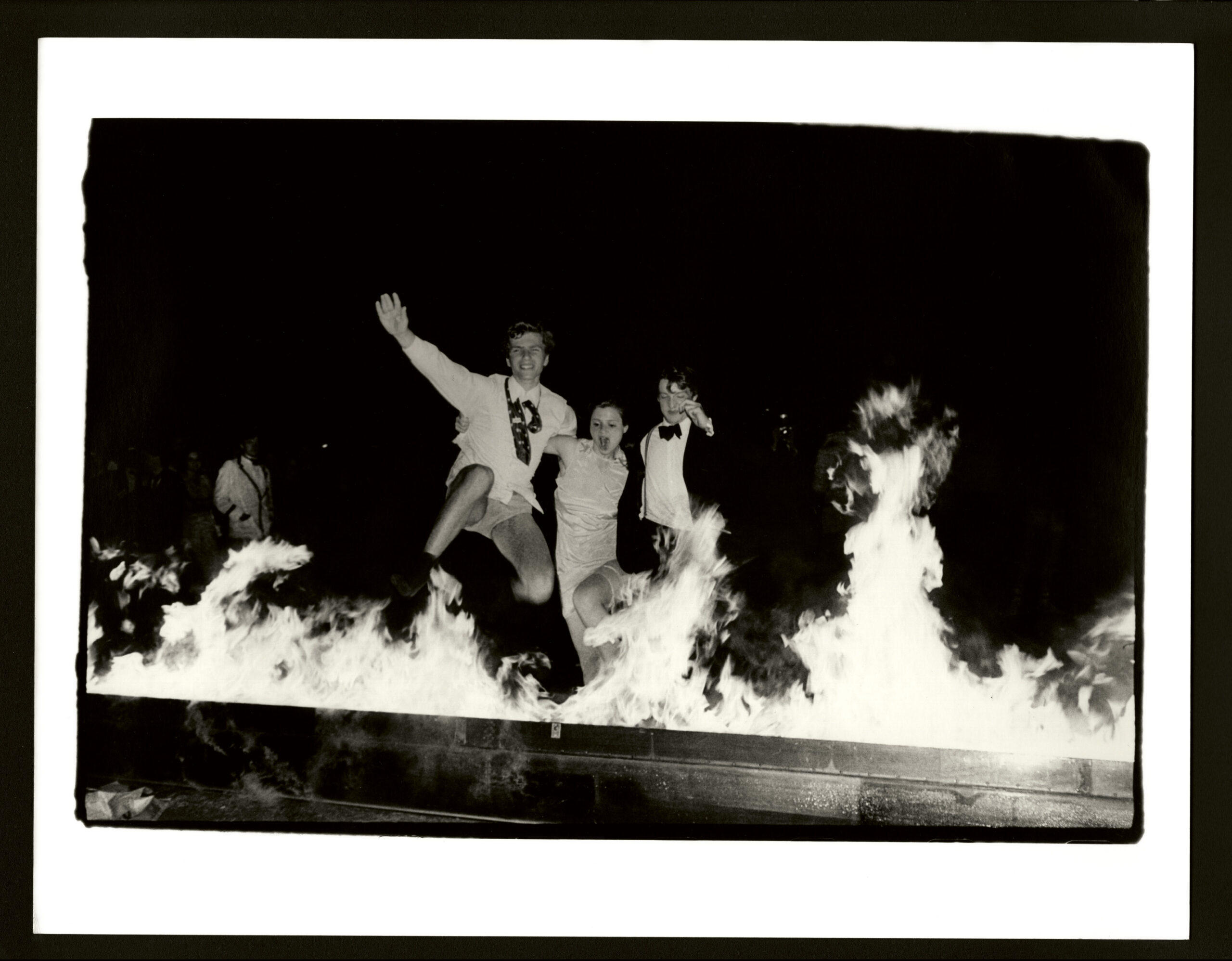 Students jump as they watch a rowing boat on fire at Cambridge May Ball