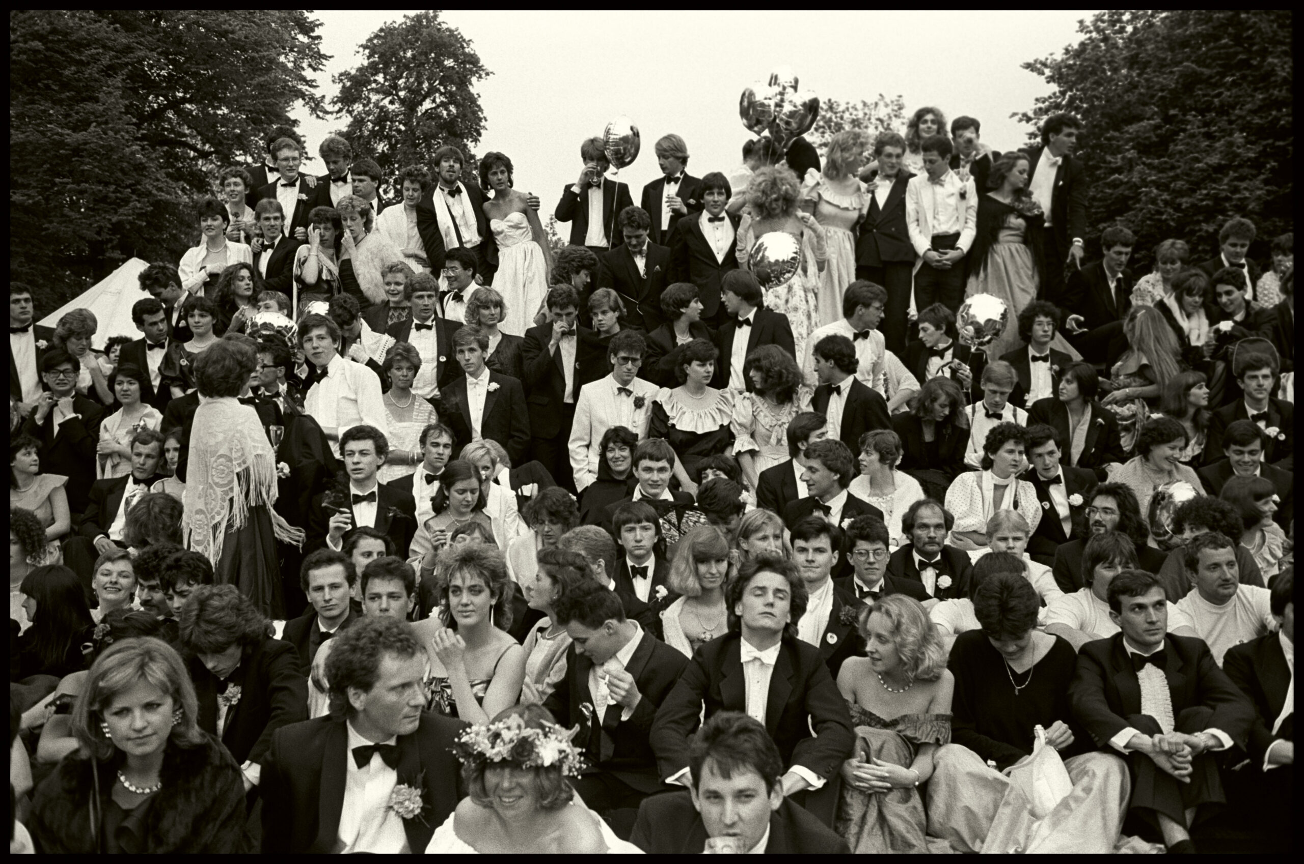 Students dressed in cocktail attire take a survivors class photo at Cambridge May Ball