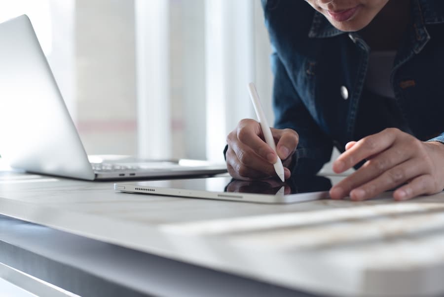 Close up of business woman using stylus pen signing e-document on digital tablet