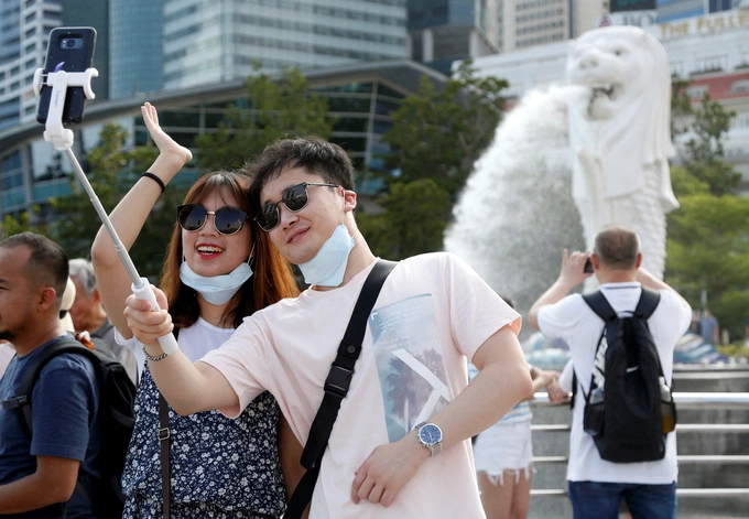 Tourists pose for photos at the Merlion Park in Singapore, Jan. 28, 2020. Photo by Reuters