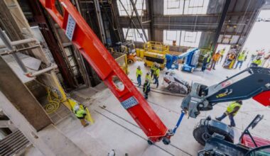 A 43-foot steel beam weighing 15,890 pounds rides 4,850 feet down an old South Dakota gold mine standing upright in a cage 4.5 feet wide, one of roughly 2,100 pieces that have to make the same trip before summer ends