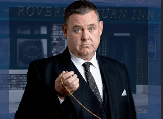 George Shuttleworth wearing his undertakers' suit, holds a pocket watch outside the Rovers