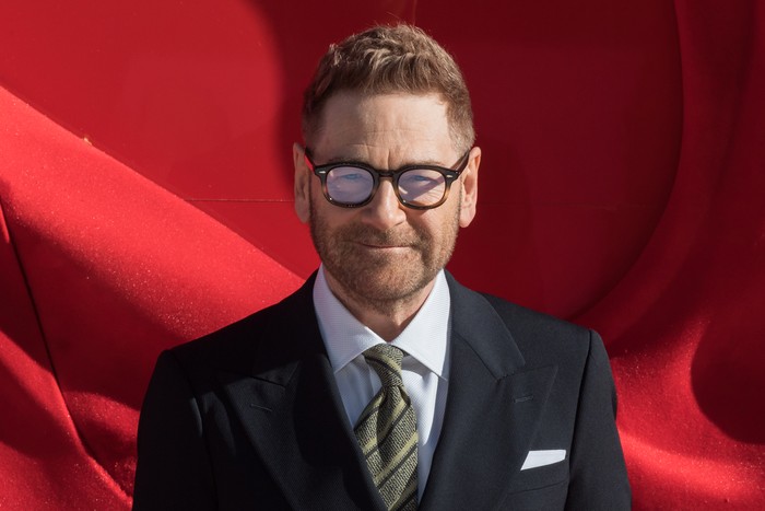 The European Premiere of 'The Devil Wears Prada 2' in London Kenneth Branagh, wearing a black suit and glasses and stood in front of a red background.