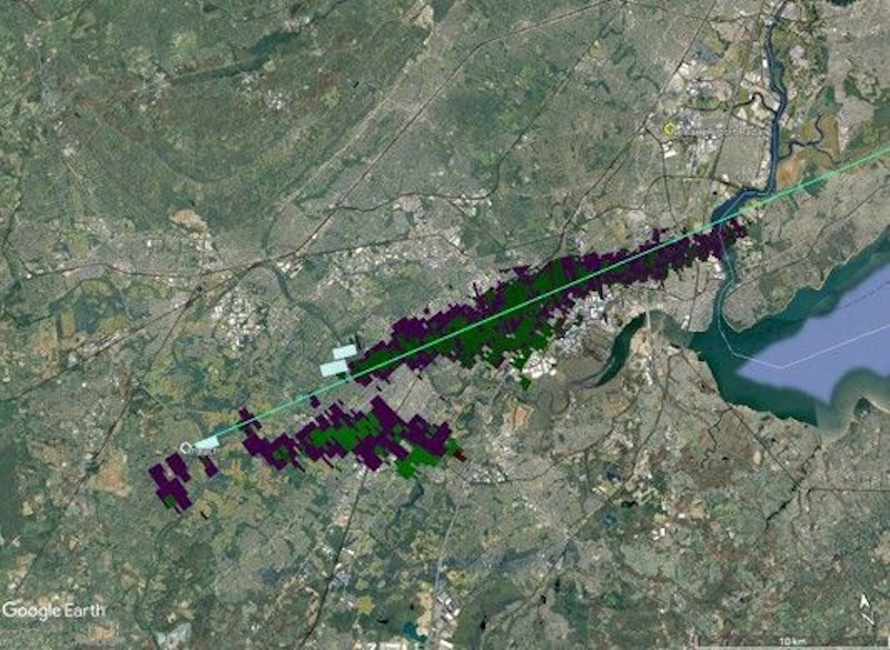 Orbital view of green terrain with a long thin line crossing over it and pixelated areas along the line.