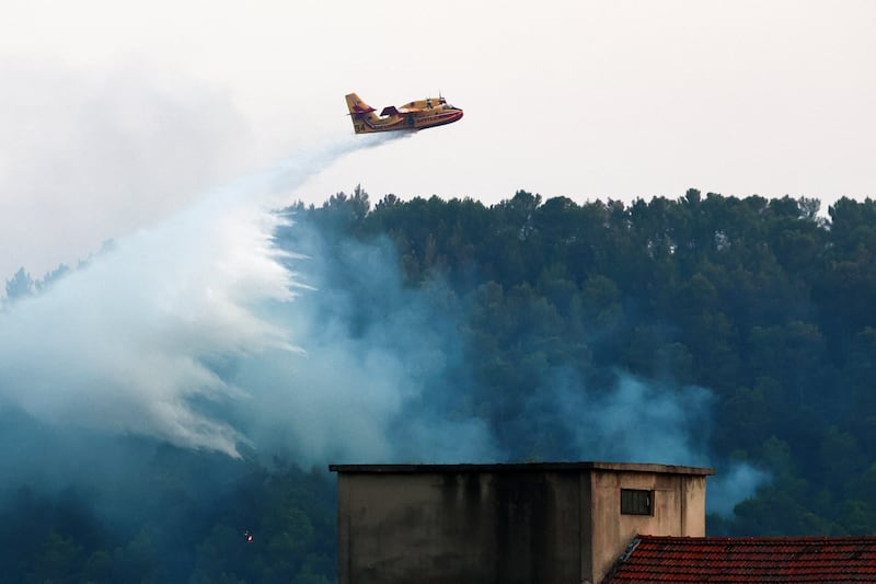 A French Civil Defense Canadair CL-415 drops water over a burning area during a wildfire in front of Barjols, southeastern France on Sunday. Photograph: Getty Images