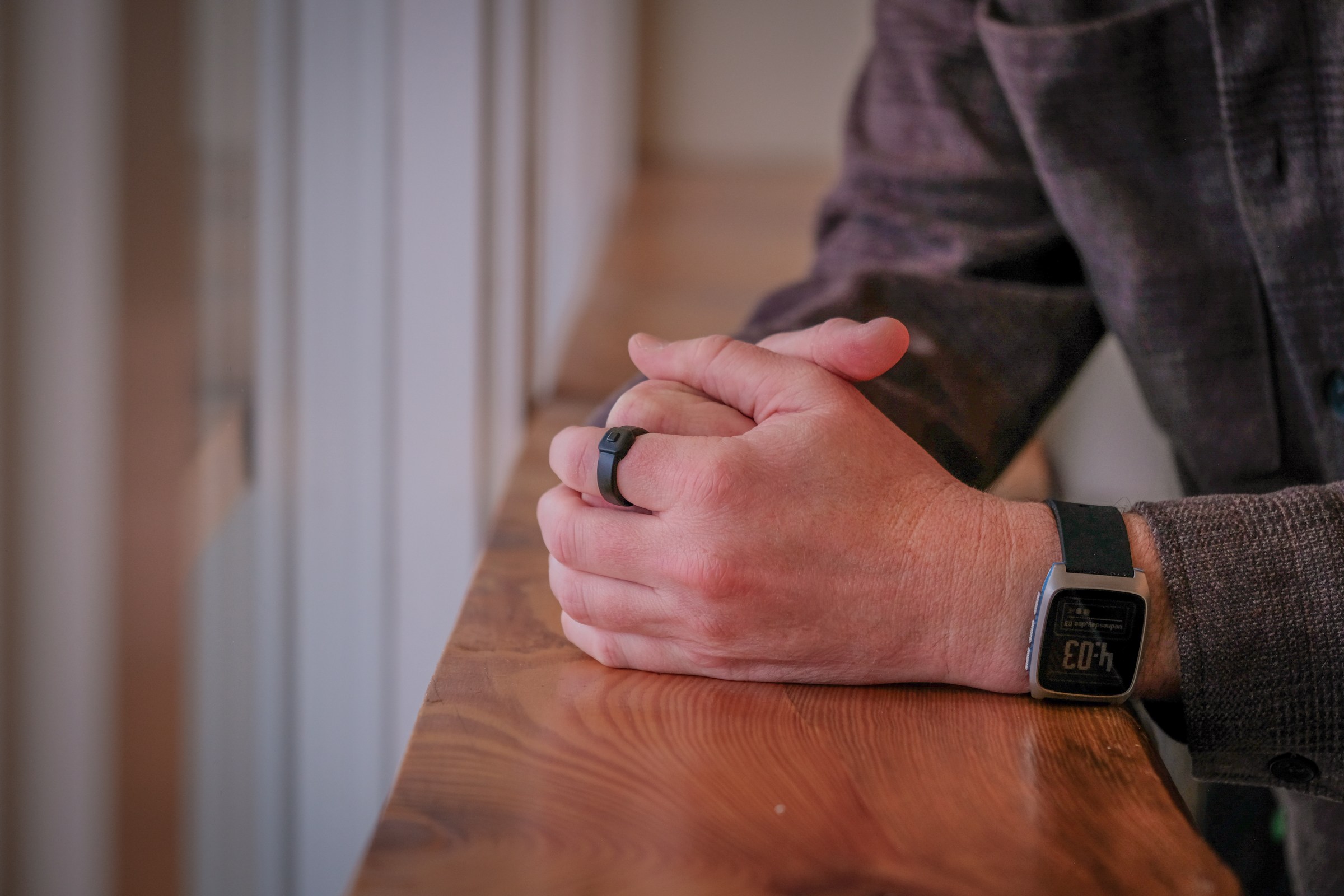 An image of a person wearing a black ring on their finger.