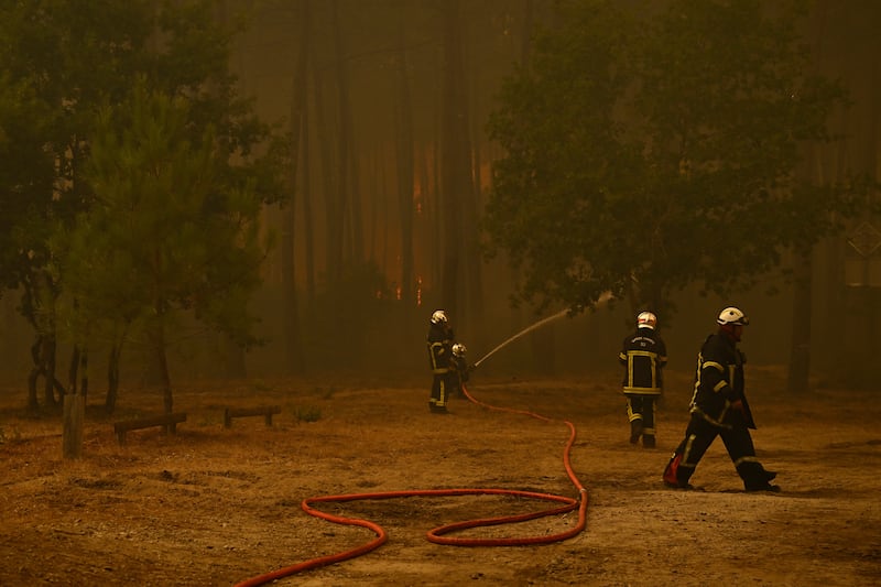 Firefighters spray water along the edge of a forest during a wildfire near the town of Lege-Cap-Ferret, in southwestern France on July 24th. Photograph: Getty Images