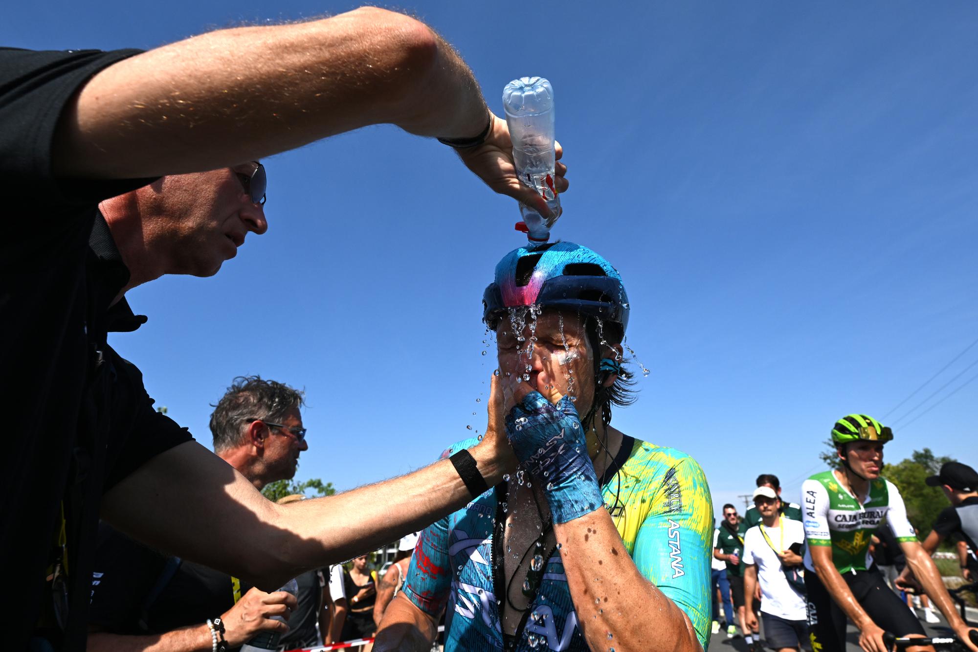 A soigneur pours a bottle of water over Aaron Gate