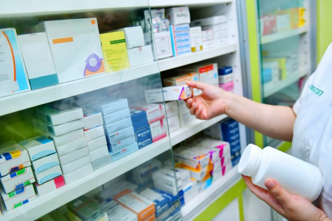 Pharmacist holding bottle of medicine and medicine box in pharmacy drugstore.; Shutterstock ID 738632569; purchase_order: -; job: -; client: -; other: -