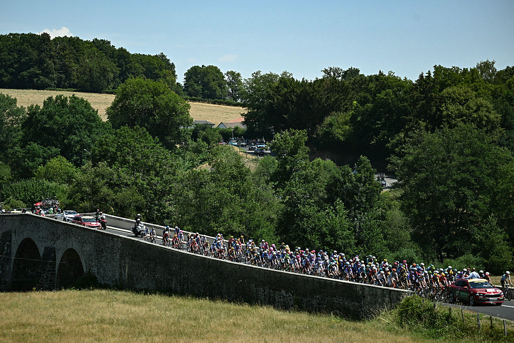 Tour de France director Christian Prudhomme gestures from atop his race direction vehicle to give the start to the pack of riders (peloton) at the start of the 10th stage of the 113th edition of the Tour de France cycling race, 166,6 km between Aurillac and Le Lioran in the Massif Central, on July 14, 2026. (Photo by Loic VENANCE / AFP)
