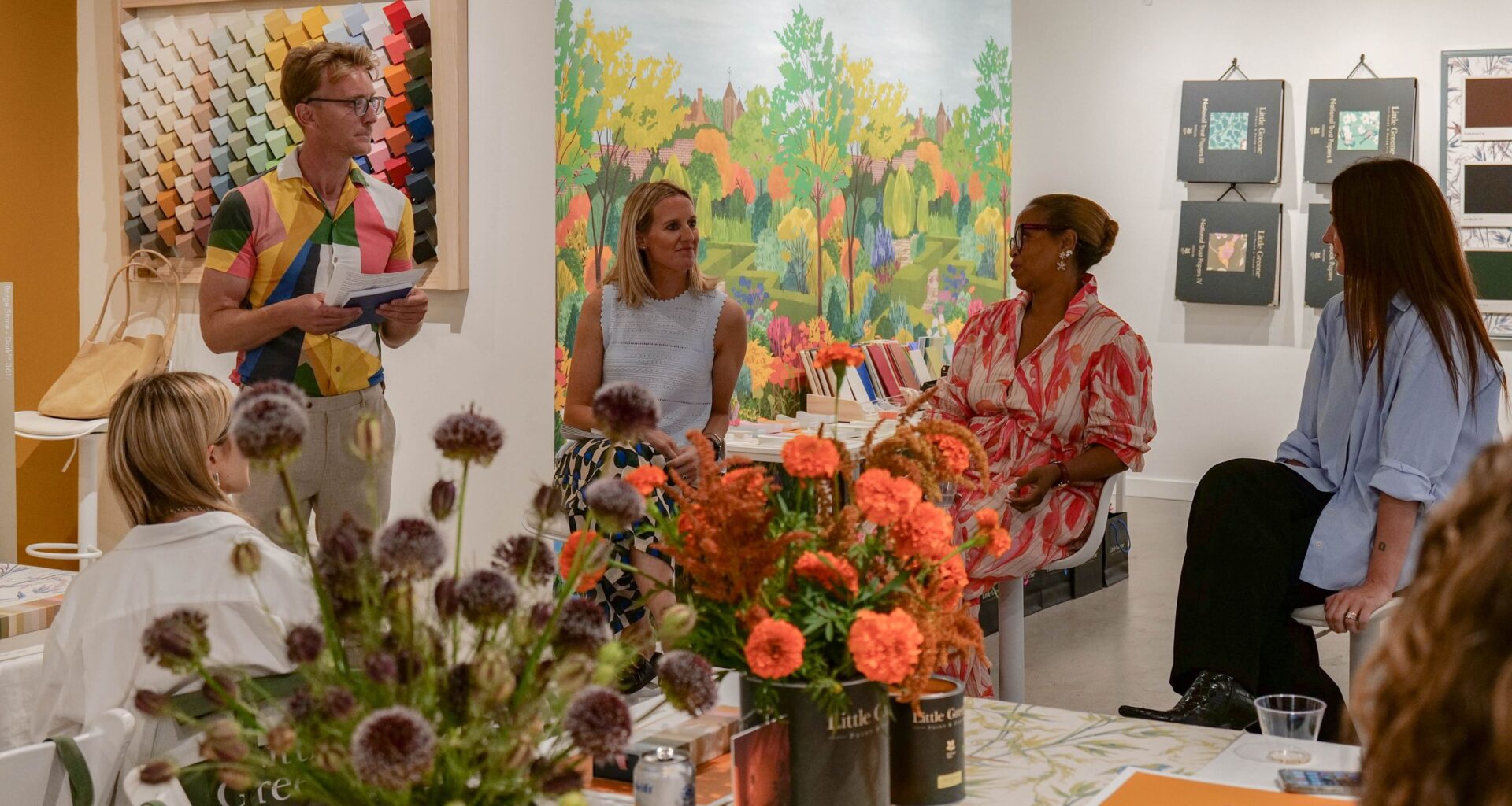 a panel of designers sat in front of a colorful backdrop