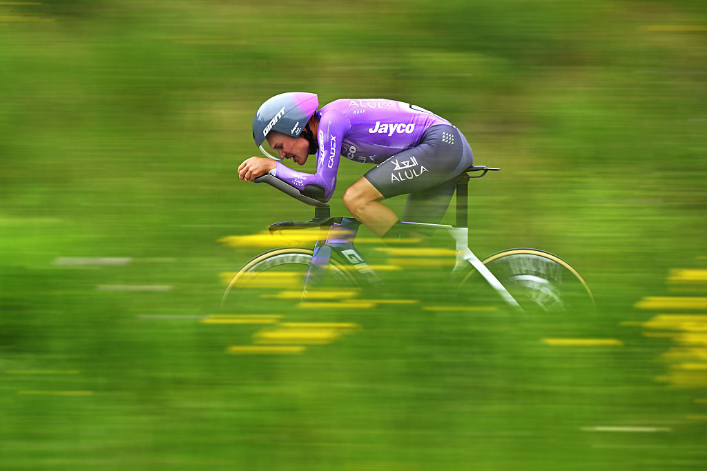 Plapp time trialing through a blurry field of green with yellow flowers