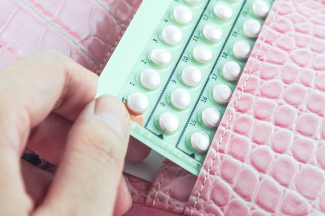 contraceptive pills in woman pink bag; Shutterstock ID 384817945; purchase_order: -; job: -; client: -; other: -