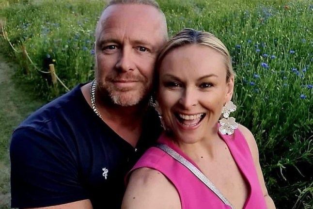 Mel Schilling and her husband take a selfie in front of grass.