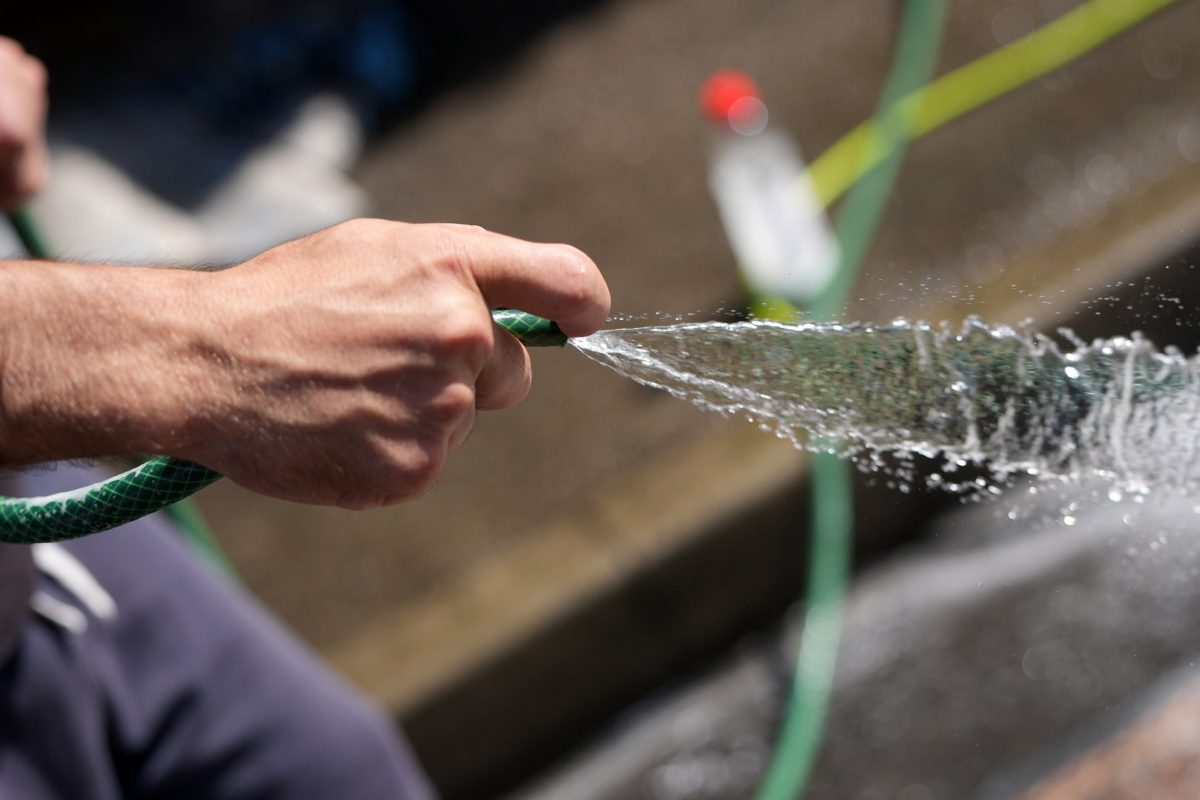 LEEDS, ENGLAND - JULY 10: On the eve of a hosepipe ban a man uses a hosepipe to clean a carpet in the street on July 10, 2025 in Leeds, England. Yorkshire Water has said a hosepipe ban will come into effect from July 11 to let reservoir levels recover, following a drought being declared after the driest spring on record. The region received only 15 centimeters of rainfall between February and June, with reservoir levels down 26.1% of normal levels for this time of year. (Photo by Christopher Furlong/Getty Images)