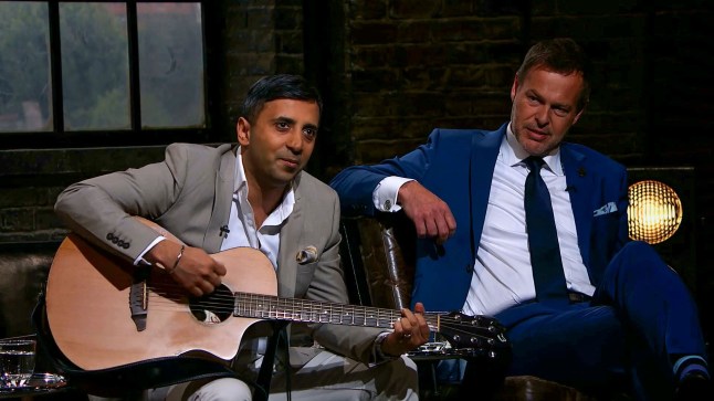Programme Name: Dragons' Den - TX: 12/08/2018 - Episode: n/a (No. 1) - Picture Shows: Tej Lalvani shows off his prowess on the guitar during a pitch, with Peter Jones listening. Tej Lalvani, Peter Jones - (C) BBC - Photographer: Screen grab