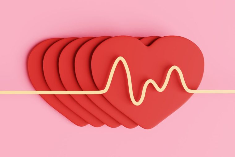 Yellow diagram of pulses on a stack of red paper hearts. Illustration of the concept of healthy lifestyles and cardiovascular related diseases