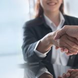 Business handshake. Business people making a handshake, close up. Two corporate businessman shaking hands during meeting in office