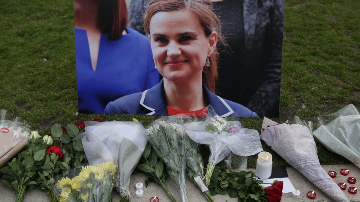 TOPSHOT - Floral tributes and candles are placed by a picture of slain Labour MP Jo Cox at a vigil in Parliament square in London on June 16, 2016. Cox died today after a shock daylight street attack, throwing campaigning for the referendum on Britain's membership of the European Union into disarray just a week before the crucial vote. (Photo by Daniel LEAL / AFP) (Photo by DANIEL LEAL/AFP via Getty Images)