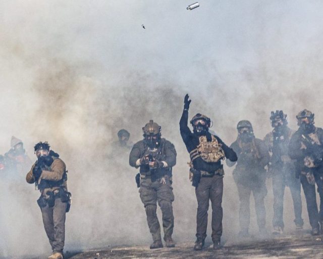 A federal agent lobs a teargas canister towards protesters as agents advance through clouds of tear gas during clashes following the fatal shooting of a protester earlier in the day, on January 24, 2026 in Minneapolis, Minnesota. Federal immigration agents shot dead a man in Minneapolis on Saturday, officials said -- the second fatal shooting of a civilian in the city, sparking fresh protests and outrage from state officials. The death came less than three weeks after US citizen Renee Good was shot and killed by an Immigration and Customs Enforcement officer involved in sweeps to round up undocumented migrants. (Photo by Kerem YUCEL / AFP via Getty Images)