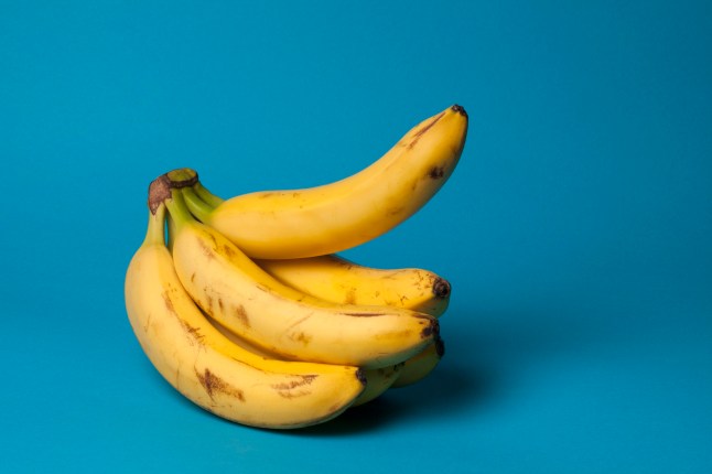 A bunch of bananas against a blue background.