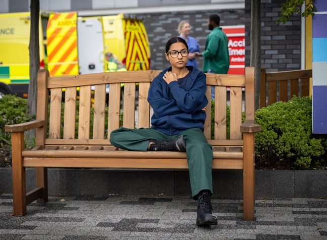 Asha Alahan sat on a bench in Coronation Street