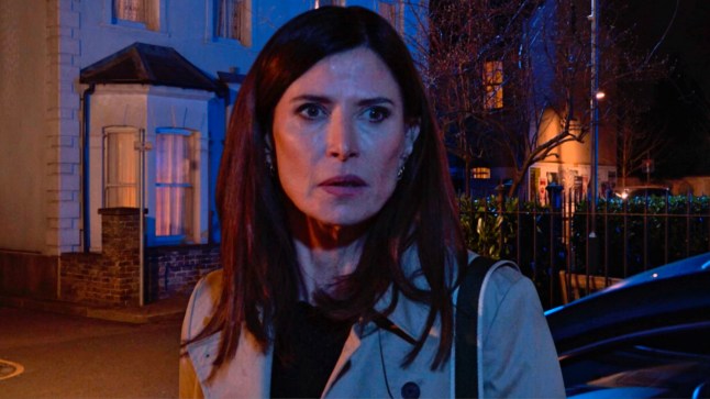 Bea Pollard looking upset in EastEnders, standing in the Square at night.