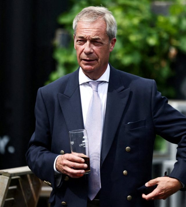 FILE PHOTO: Leader of the Reform UK party Nigel Farage holds a glass at a pub, after he announced on Tuesday that he has resigned as an MP, triggering a by-election in his parliamentary seat, where he intends to stand for re-election, in Great Bentley, Britain, July 8, 2026. REUTERS/Jack Taylor/File Photo