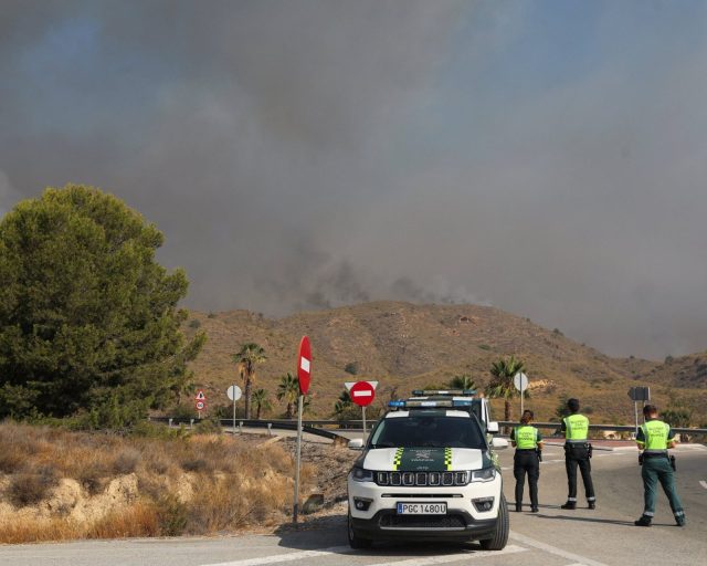 Members of the Spanish Civil Guard stand guard as smoke rises from a wildfire in Los Gallardos, Almeria, Spain, July 10, 2026. REUTERS/Loyola Perez de Villegas Muniz
