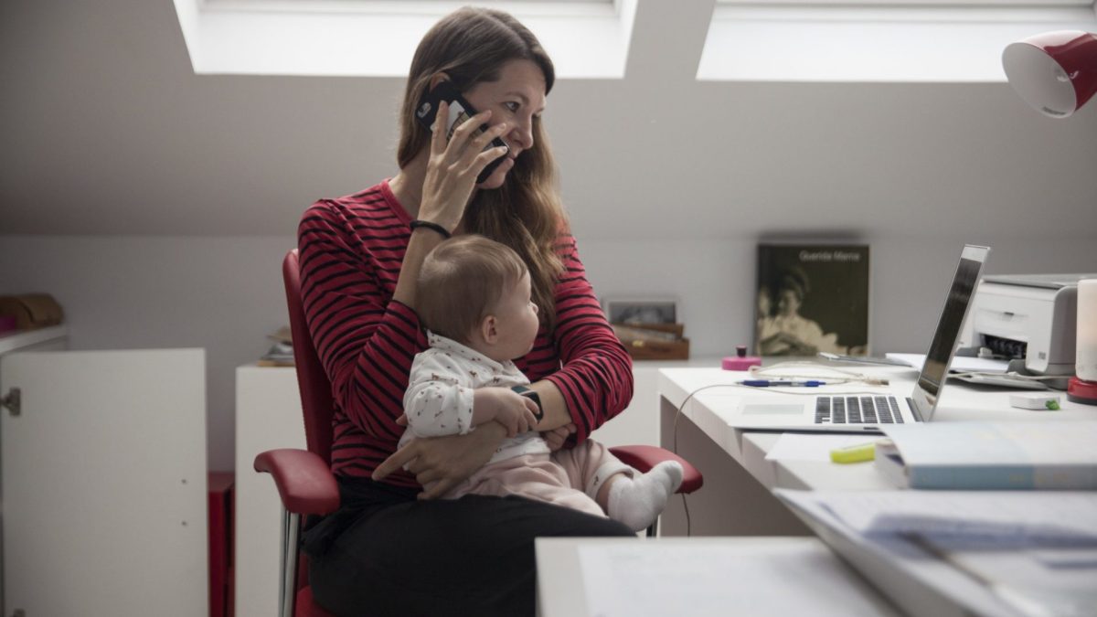 MAJADAHONDA, MADRID, SPAIN - MAY 11. Virginia Bejar, the photographer's partner, strives to work at home while holding her six-month-old daughter Olivia, also the photographer's daughter, during the Covid-19 lockdown on May 11, 2020, in Majadahonda, Madrid, Spain. Some parts of Spain have entered "Phase One" of transition from the coronavirus lockdown, allowing many shops to reopen as well as restaurants who serve customers outdoors. Locations that were harder hit by coronavirus (COVID-19), such as Madrid and Barcelona, remain in a stricter "Phase 0" quarantine. Across the country workers who can do their jobs from home like Bejar are obliged to do so. In fact,??? most business offices still remain closed. (Photo by Miguel Pereira/Getty Images)