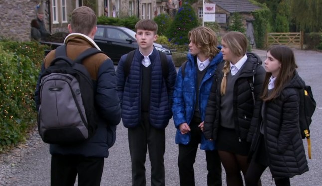 Elliot standing next to Heath, Cathy and April, facing Arthur in Emmerdale