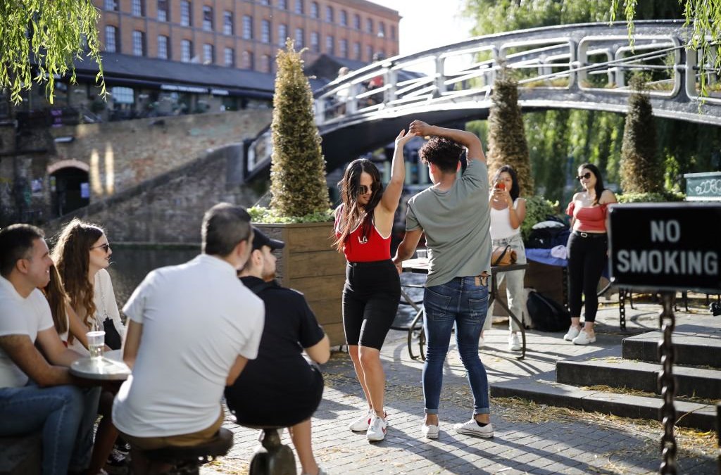 a couple dance the salsa alongside Camden Lock in north London on May 28, 2020, as lockdown measures are eased during the novel coronavirus COVID-19 pandemic. (Photo by Tolga Akmen / AFP) (Photo by TOLGA AKMEN/AFP via Getty Images)