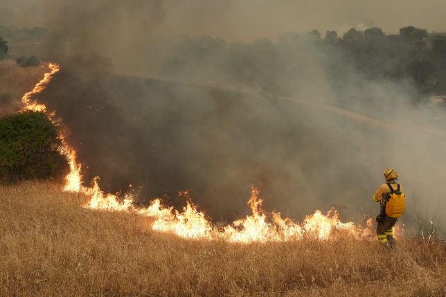 TOPSHOT - Firefighters battle a wildfire in Cebreros area, near Avila, 80 kms west of Madrid on July 24, 2026. Spain declared a national emergency in the Madrid region and in the province of Avila, near the capital, on July 23, 2026, in the wake of several wildfires burning out of control. Scientists have long warned that climatechange caused by human use of fossil fuels will make periods of drought more intense and longer-lasting, creating the ideal conditions for wildfires. (Photo by Cesar MANSO / AFP via Getty Images)