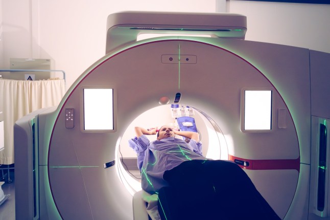 A young multiracial female is undergoing a diagnostic medical imaging procedure in a state-of-the-art hospital setting with CT simulator. The image illustrates the use of cutting-edge technology for healthcare and treatment in a modern medical environment. The portrayal highlights precision, care, and the sophistication of contemporary medical practices.