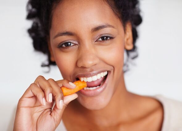 Woman eating carrot