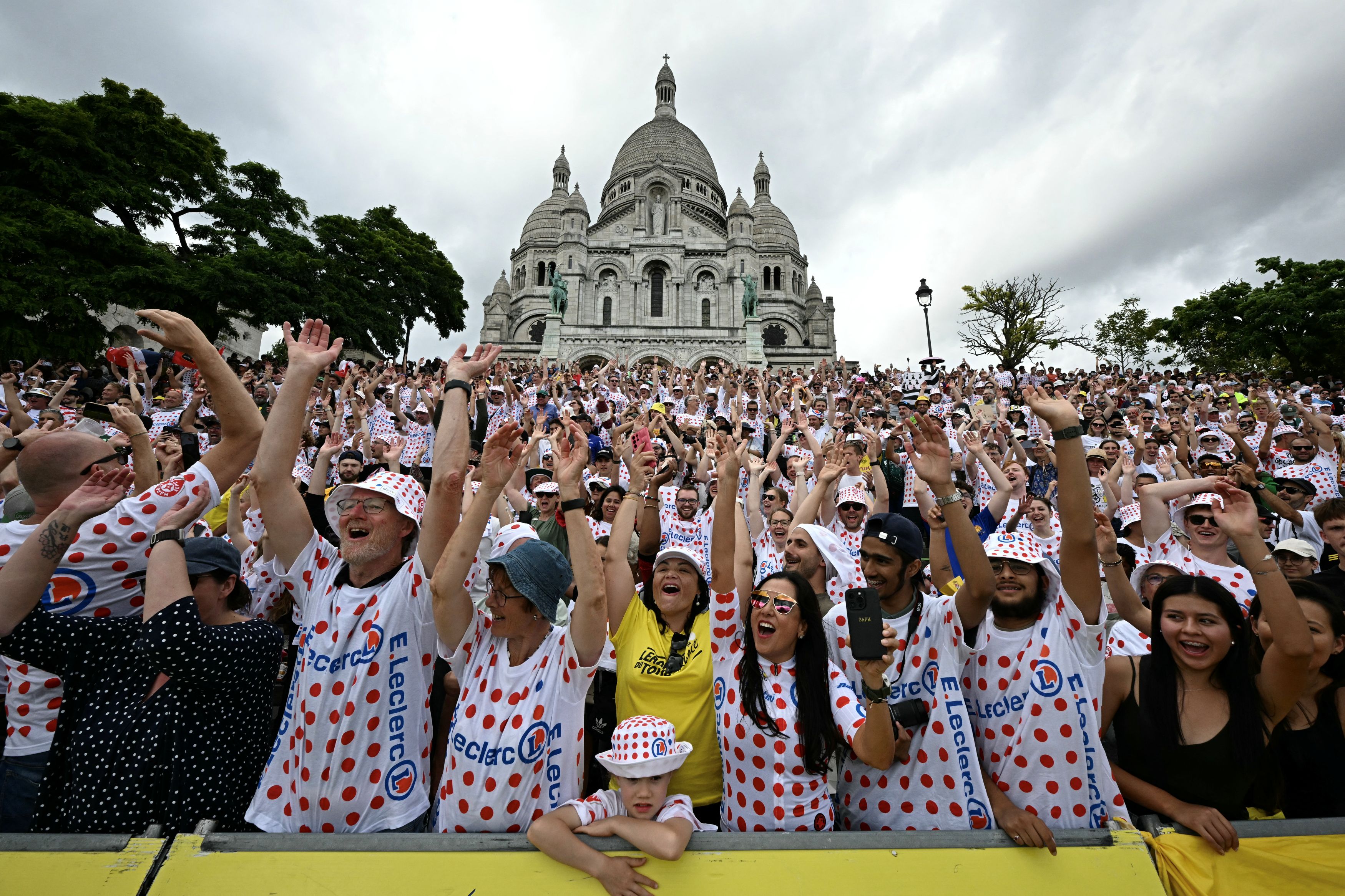 Spectators cheer as they gather in front of the Sacre Coeur basilica before the 21st stage of the 113th edition of the Tour de France cycling race, 88,7 km starting and finishing in Paris, on July 26, 2026. (Photo by Loic VENANCE / AFP via Getty Images)