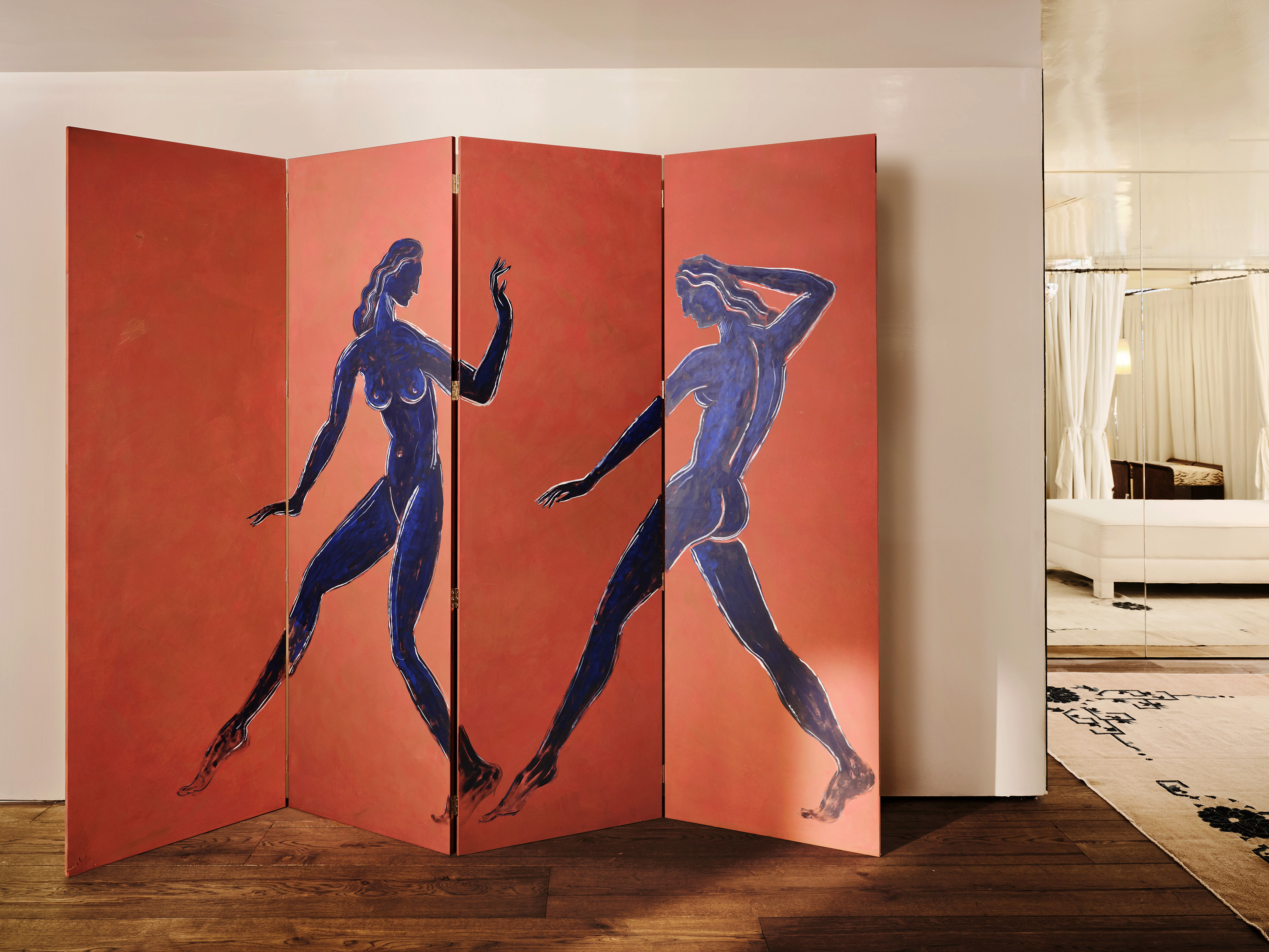 The glossy, curated interiors of a fashion boutique inspired by Italian design and architecture, with marble surfaces, statement chandeliers, and artsy separes interspersed with eye-catching clothing.