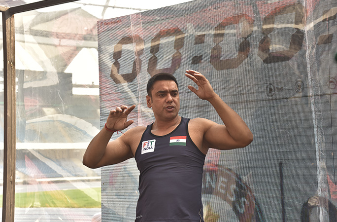 a man stretches his arm out with a clock timer in the background